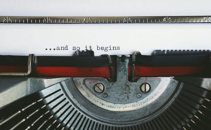 A typewriter page reading ‘…and so it begins’ — the first dispatch for solo entrepreneurs